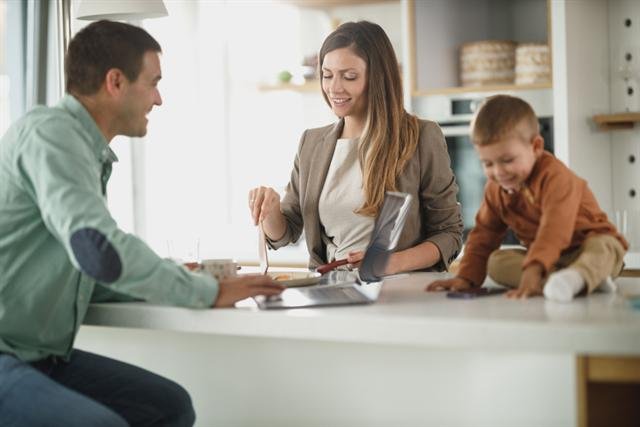 Familia convive en casa mientras usa una laptop y una tablet