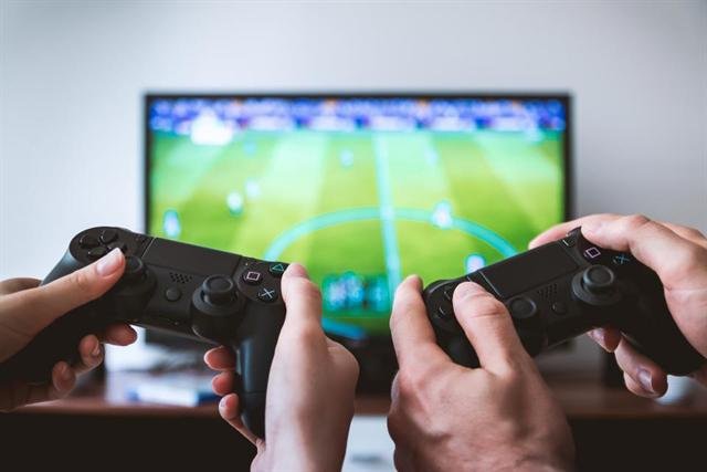 Dos personas jugando videojuegos frente a la televisión